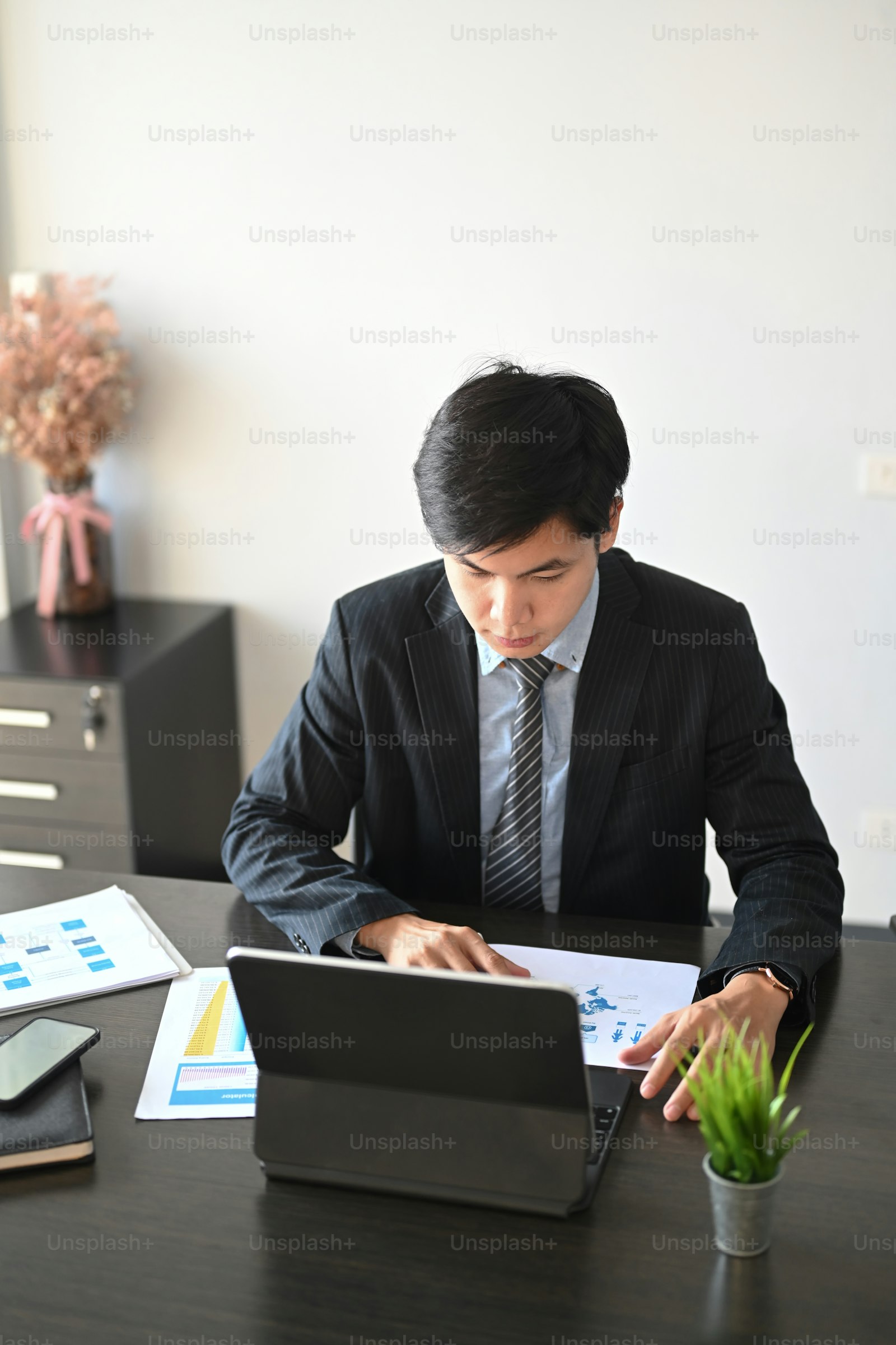 Person in a suit reviewing reports at a desk